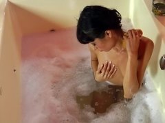 Hot slut is by the tub, massaging her wet and sexy pussy