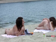 Stunning young nudist babes relax at the beach