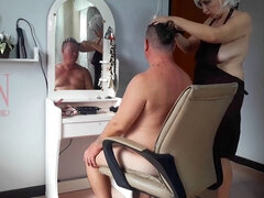 Aproned hairdresser in a naturist barbershop surprises client with a strip tease!